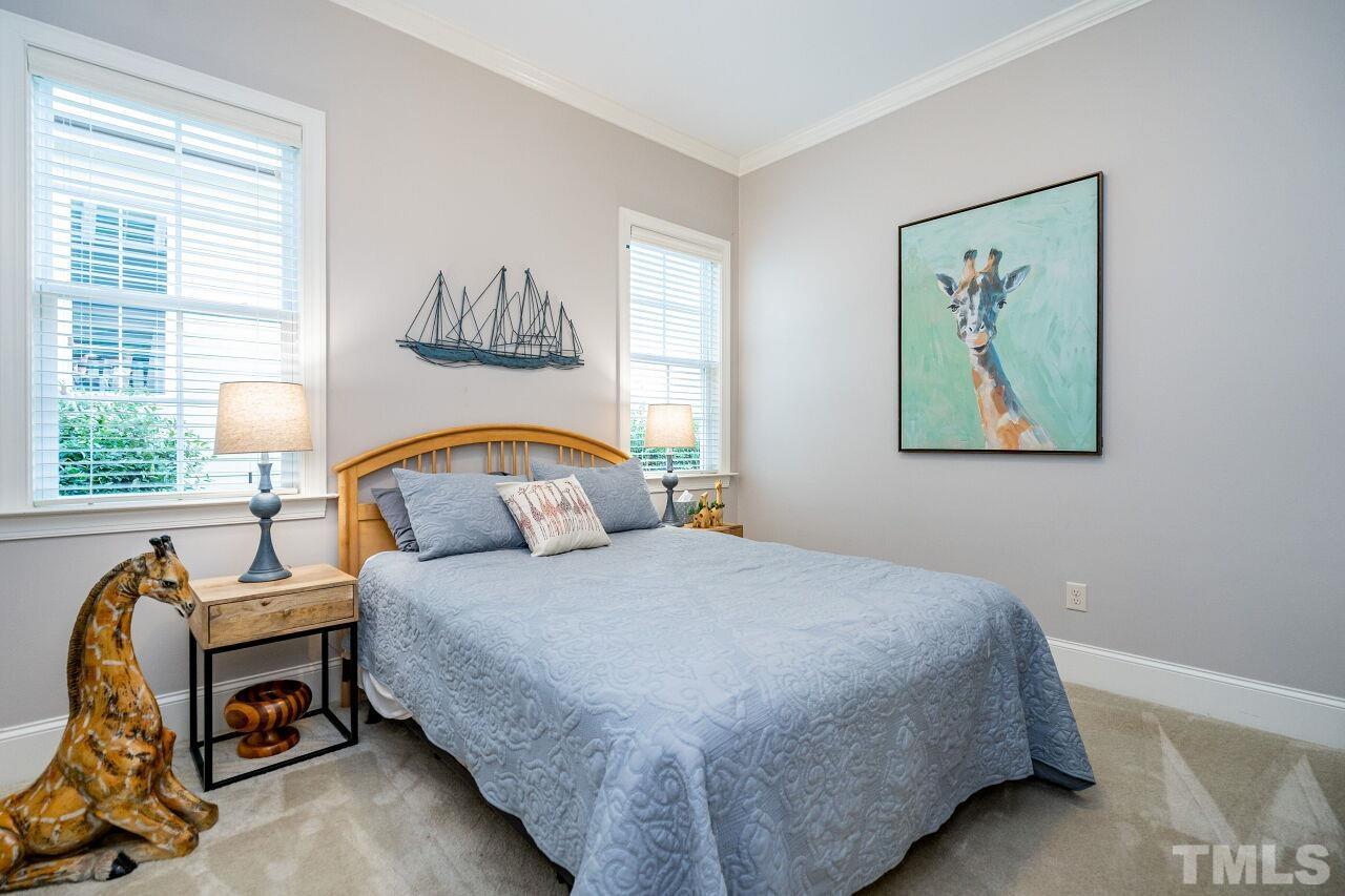 8035 Brandyapple Drive Raleigh, NC 27615 - Photo 19 of 30 First floor bedroom with ceiling crown and carpet floors.