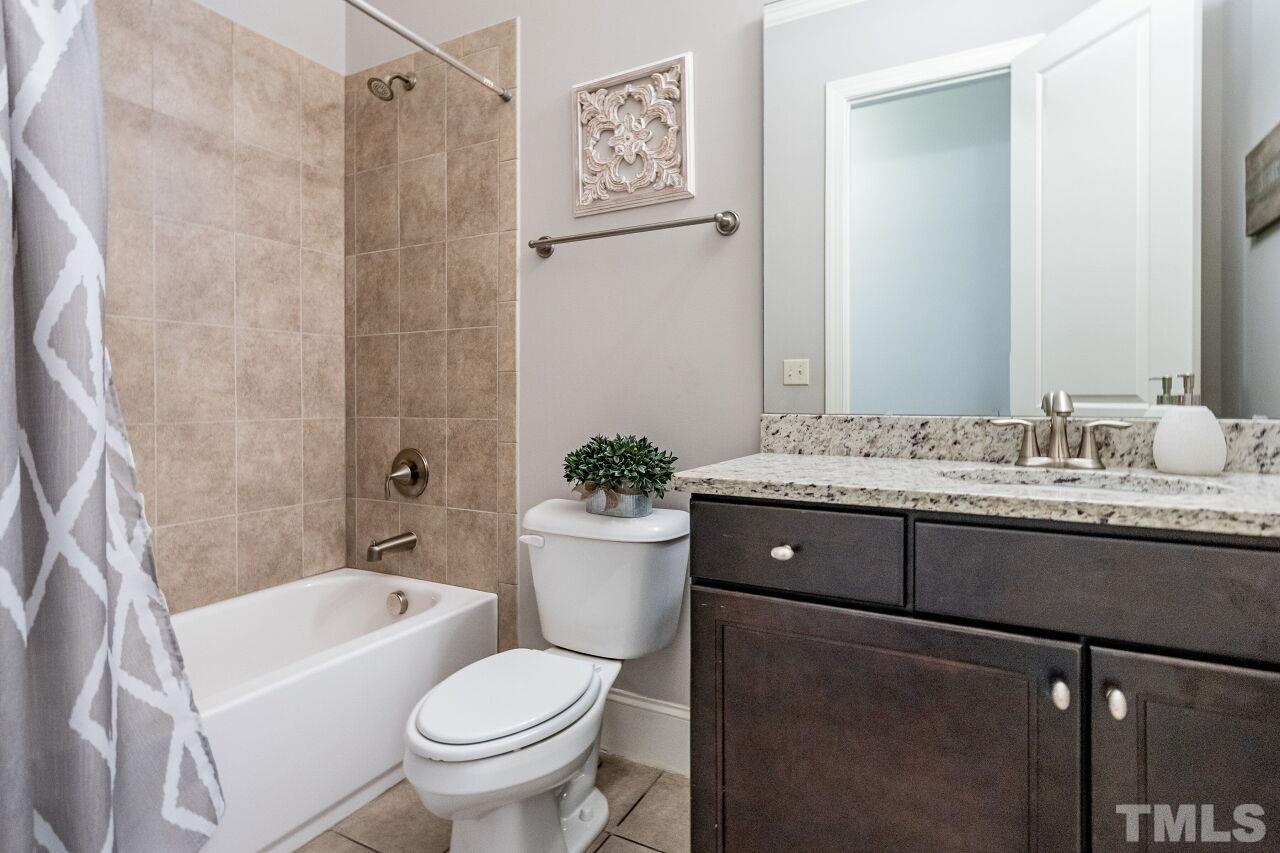 8035 Brandyapple Drive Raleigh, NC 27615 - Photo 20 of 30 First floor full bath with granite tops, tile tub/shower and tile floors.