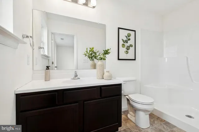 a bathroom with a toilet a sink and mirror