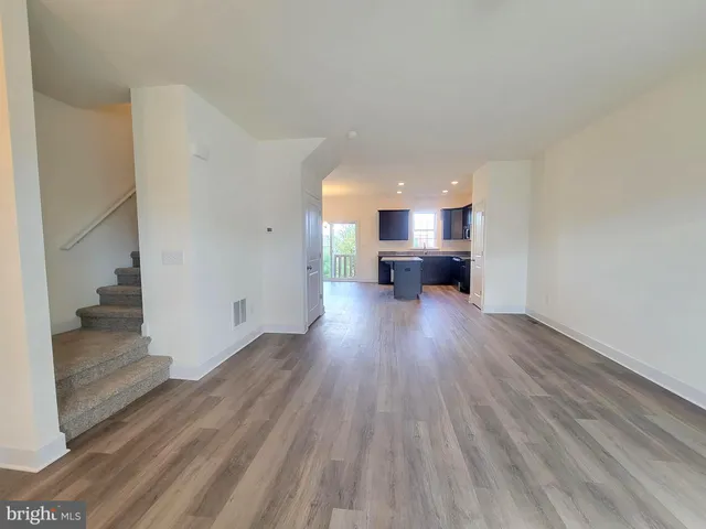 a view of a living room hardwood floor and a kitchen