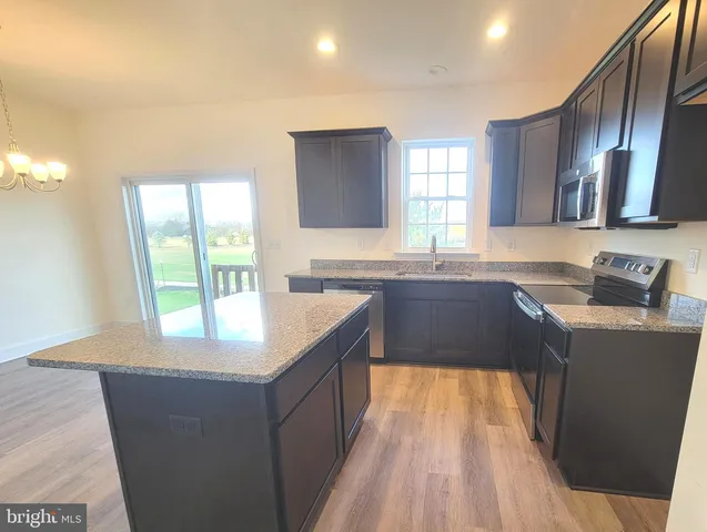 a kitchen with granite countertop a stove and a sink