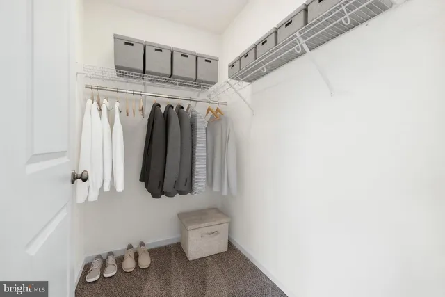 a view of walk in closet with clothes and shoes