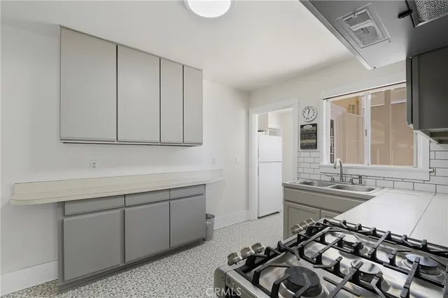 a kitchen with a sink stove and cabinets