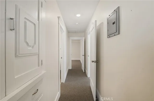 a view of a hallway with wooden shelves