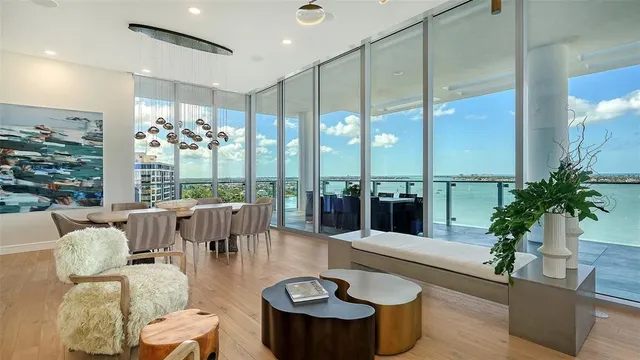a living room with furniture potted plant and large windows