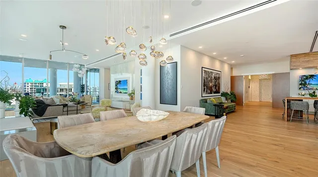 a view of a dining room and livingroom with furniture wooden floor a chandelier