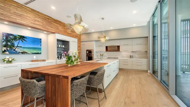 a kitchen with stainless steel appliances kitchen island granite countertop a table chairs sink and cabinets