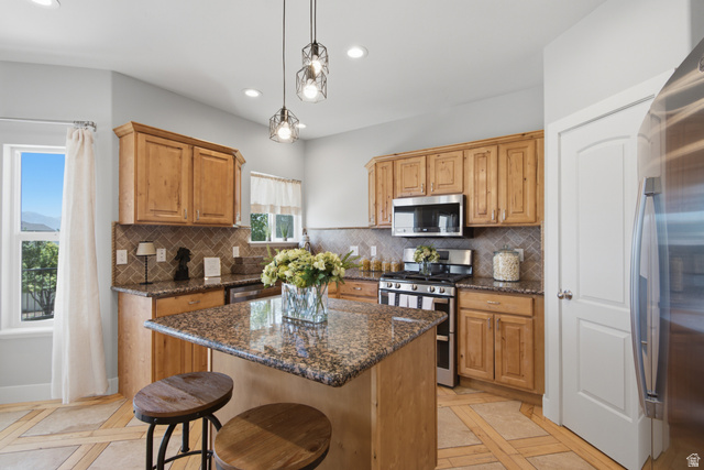 1252 Skyline Road Saratoga Springs, UT 84045 - Photo 15 of 51 Kitchen featuring light wood cabinetry, granite countertops, a tiled backsplash, and stainless steel appliances