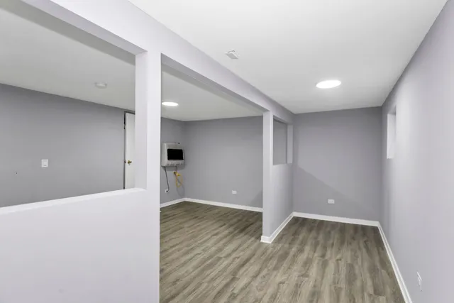 a view of a big room with wooden floor and windows