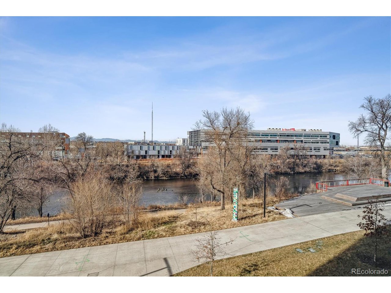 3575 Chestnut Place, Unit 406 Denver, CO 80216 - Photo 16 of 16 a view of a lake with a building in the background