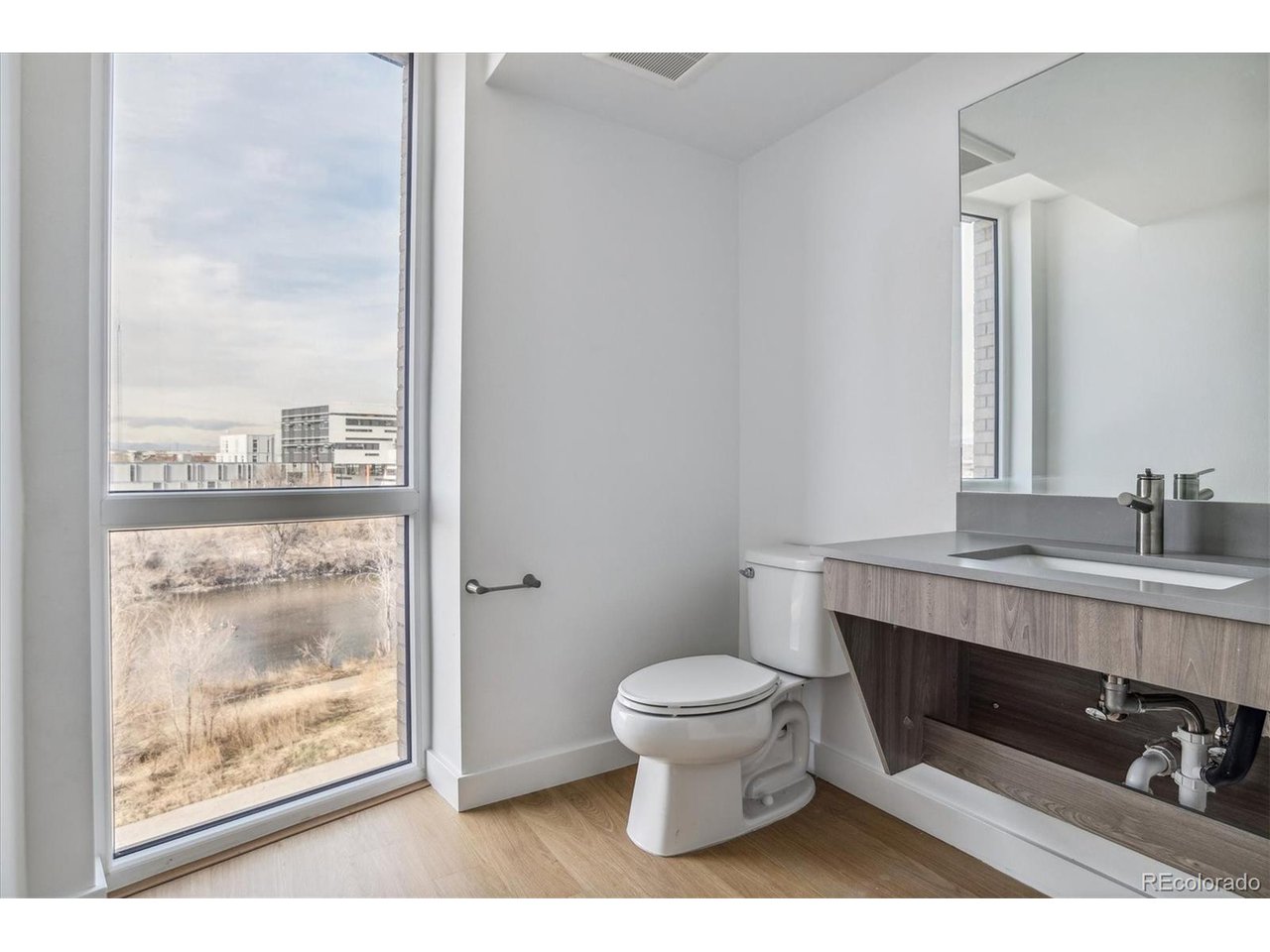 3575 Chestnut Place, Unit 406 Denver, CO 80216 - Photo 8 of 16 a bathroom with a toilet a sink and a mirror