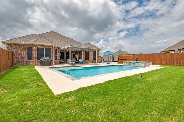an aerial view of a house with a garden and lake view