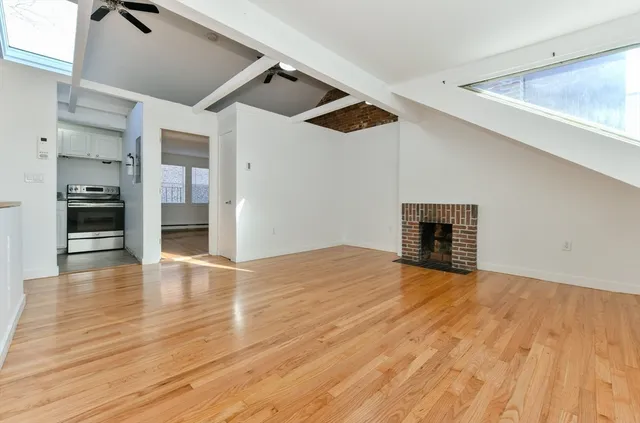 a view of empty room with wooden floor and appliances