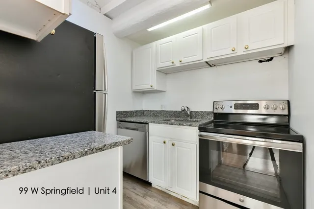 a kitchen with granite countertop a stove and a sink