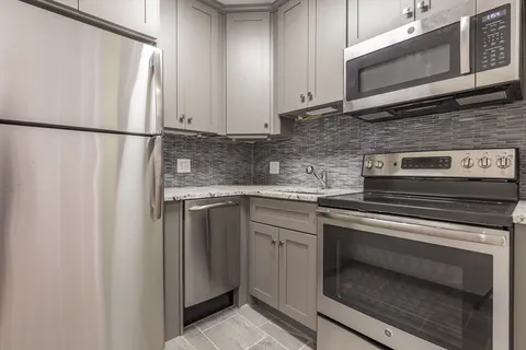 a kitchen with stainless steel appliances granite countertop a refrigerator stove a sink and dishwasher