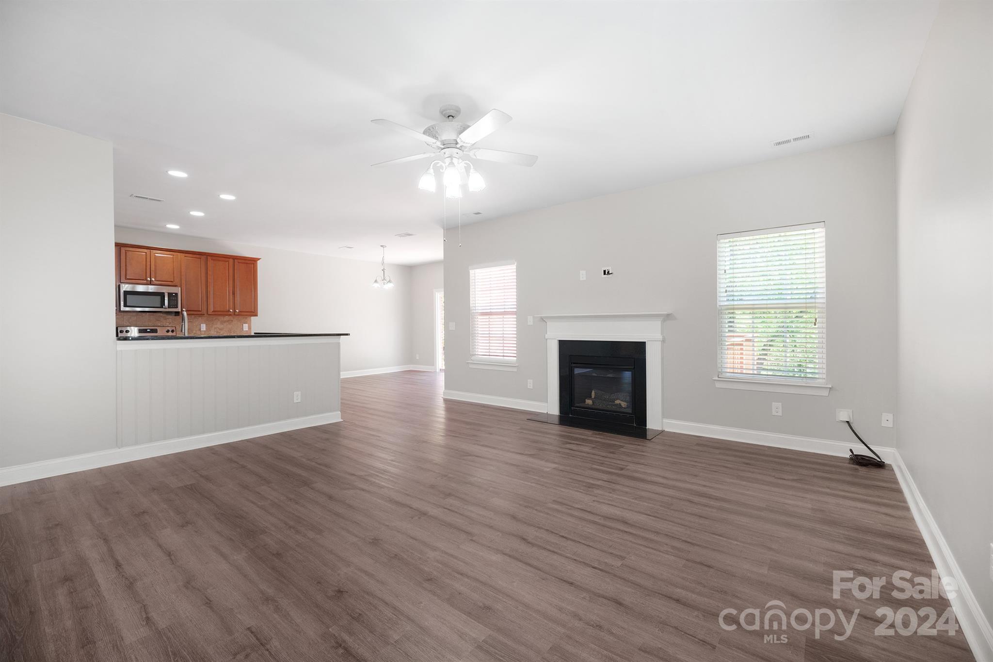 4009 Thorndale Road Indian Trail, NC 28079 - Photo 11 of 48 an empty room with wooden floor fireplace and windows
