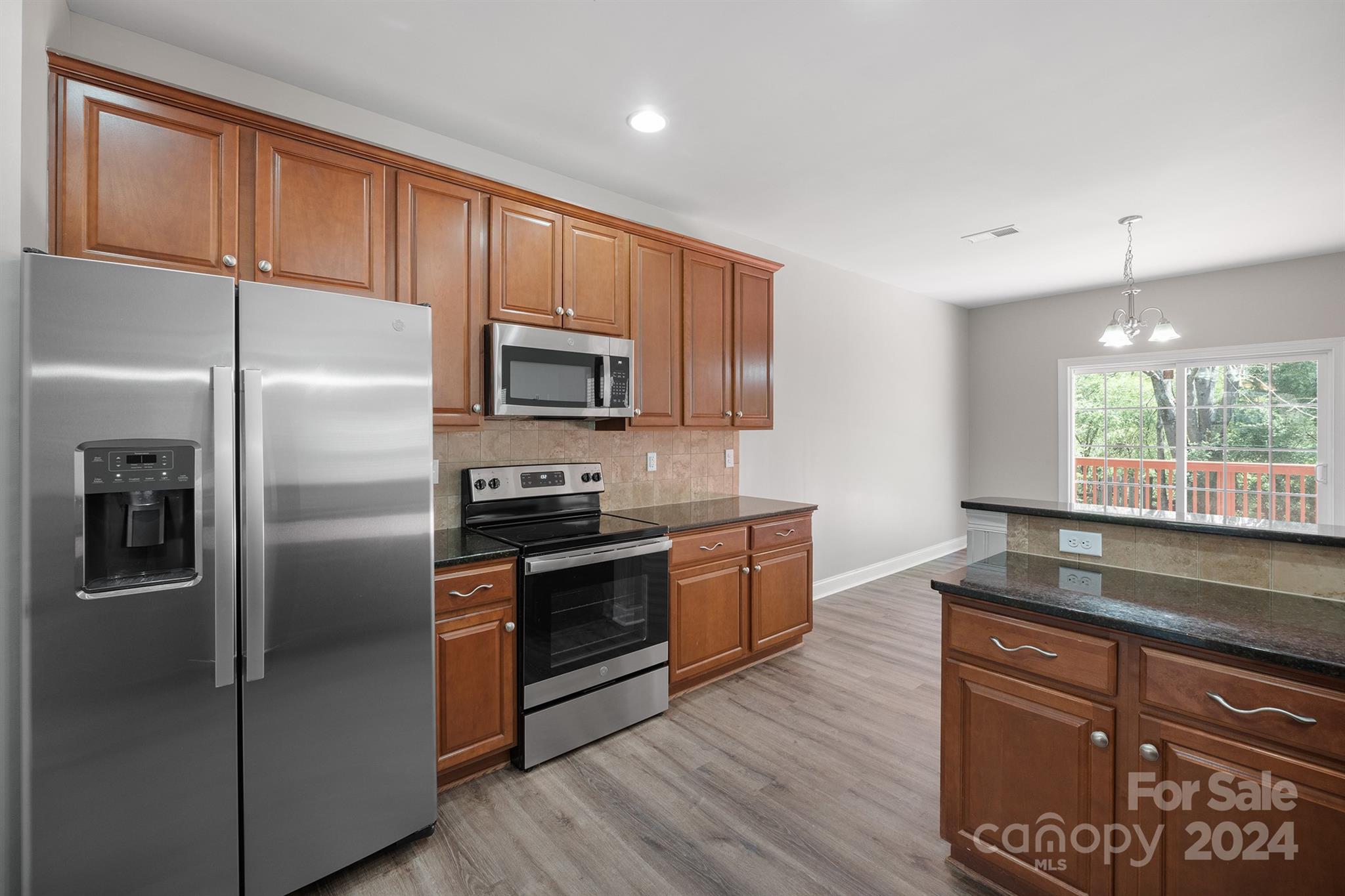 4009 Thorndale Road Indian Trail, NC 28079 - Photo 14 of 48 a kitchen with granite countertop stainless steel appliances a refrigerator stove microwave and cabinets