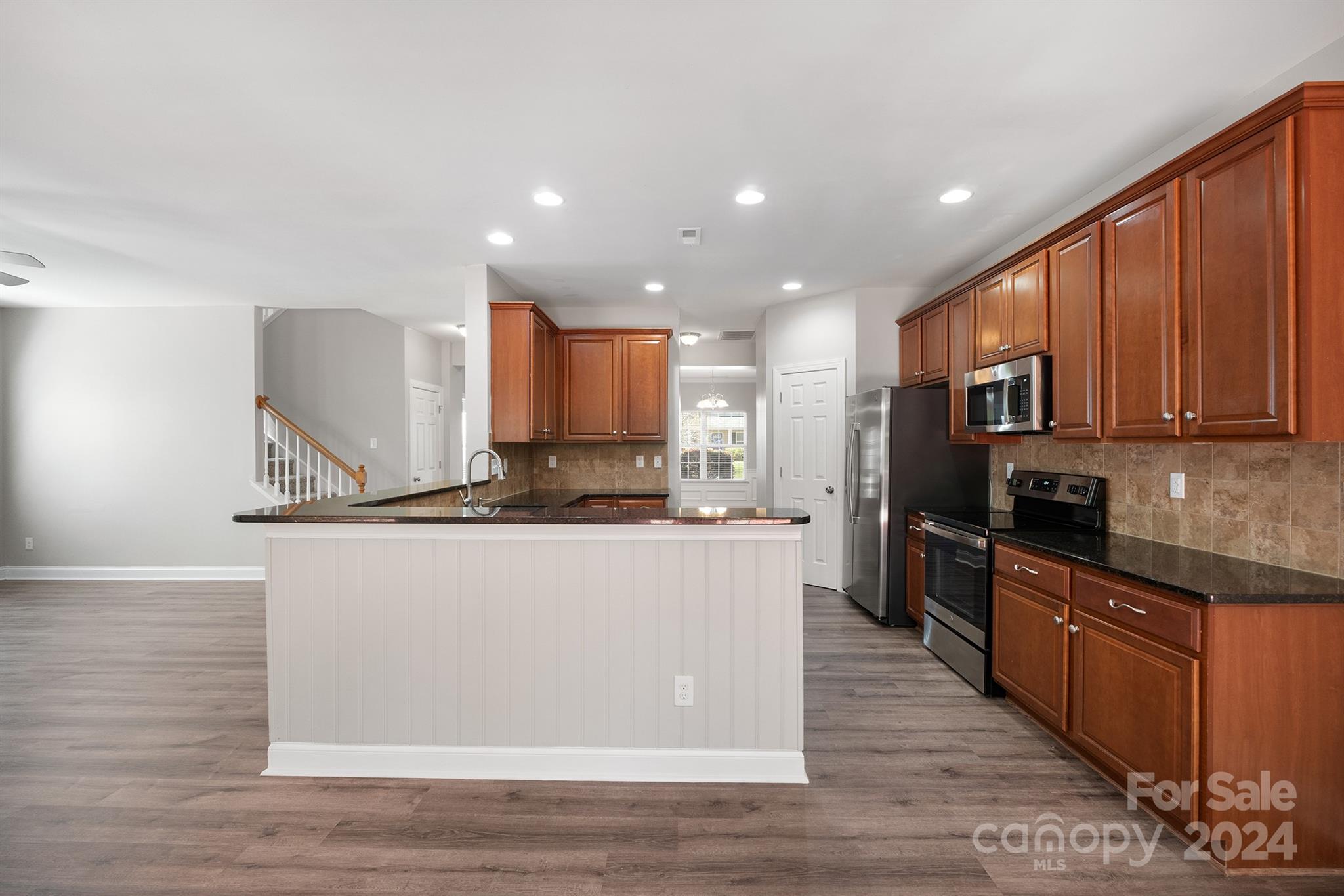 4009 Thorndale Road Indian Trail, NC 28079 - Photo 15 of 48 a large kitchen with stainless steel appliances granite countertop a stove a sink a refrigerator and a microwave