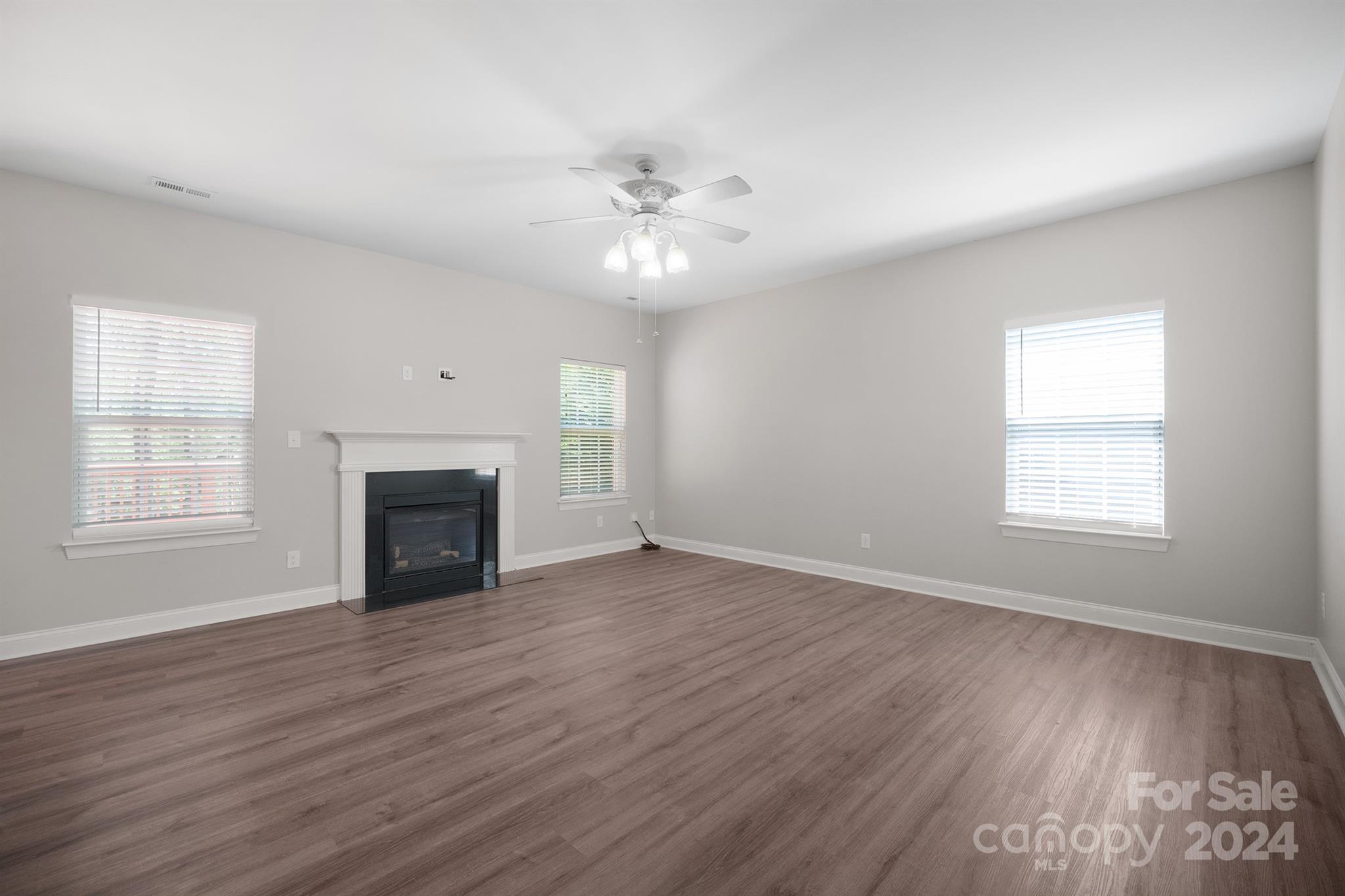 4009 Thorndale Road Indian Trail, NC 28079 - Photo 3 of 48 an empty room with windows fireplace and wooden floor