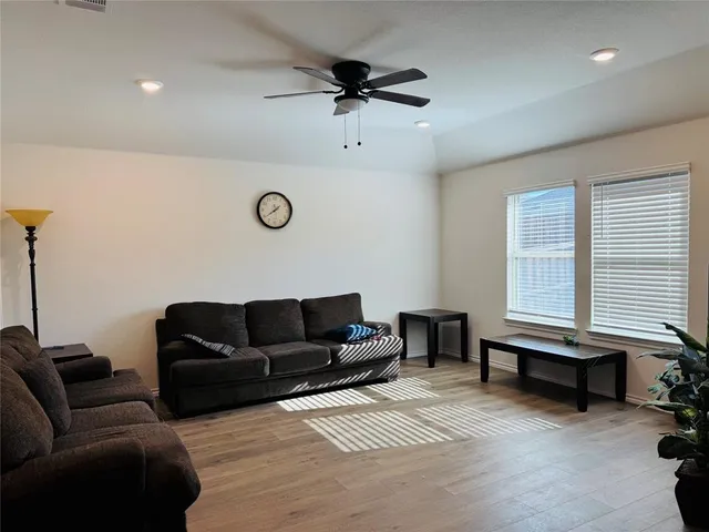 a living room with furniture ceiling fan and a window