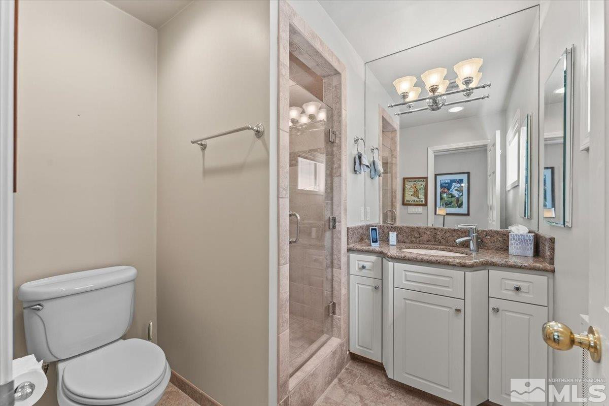 449 Fairview Boulevard Incline Village, NV 89451 - Photo 30 of 40 a bathroom with a granite countertop sink toilet a large mirror and shower
