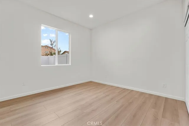 an empty room with wooden floor and window
