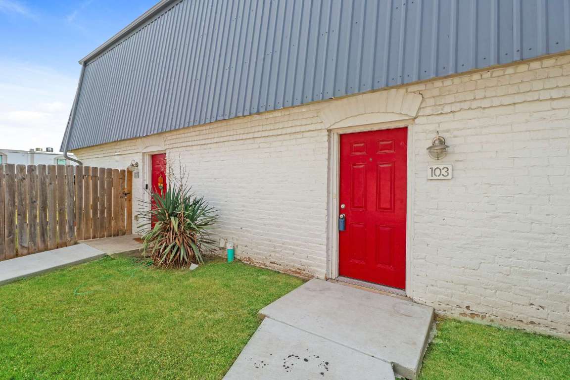 7202 Twin Crest Drive, Unit 103 Austin, TX 78752 - Photo 1 of 14 a backyard of a house with plants and wooden fence