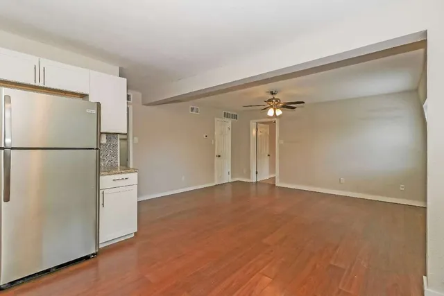 a view of an empty room with a kitchen