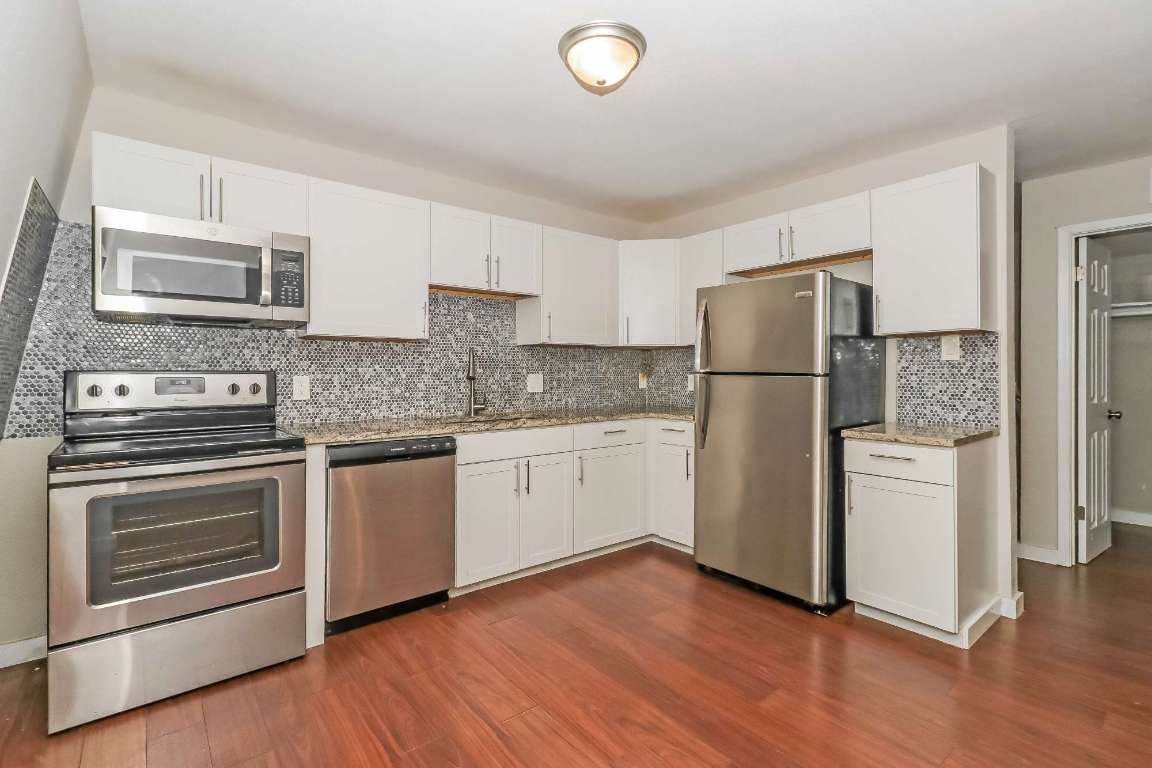 7202 Twin Crest Drive, Unit 103 Austin, TX 78752 - Photo 6 of 14 a kitchen with a refrigerator sink and microwave