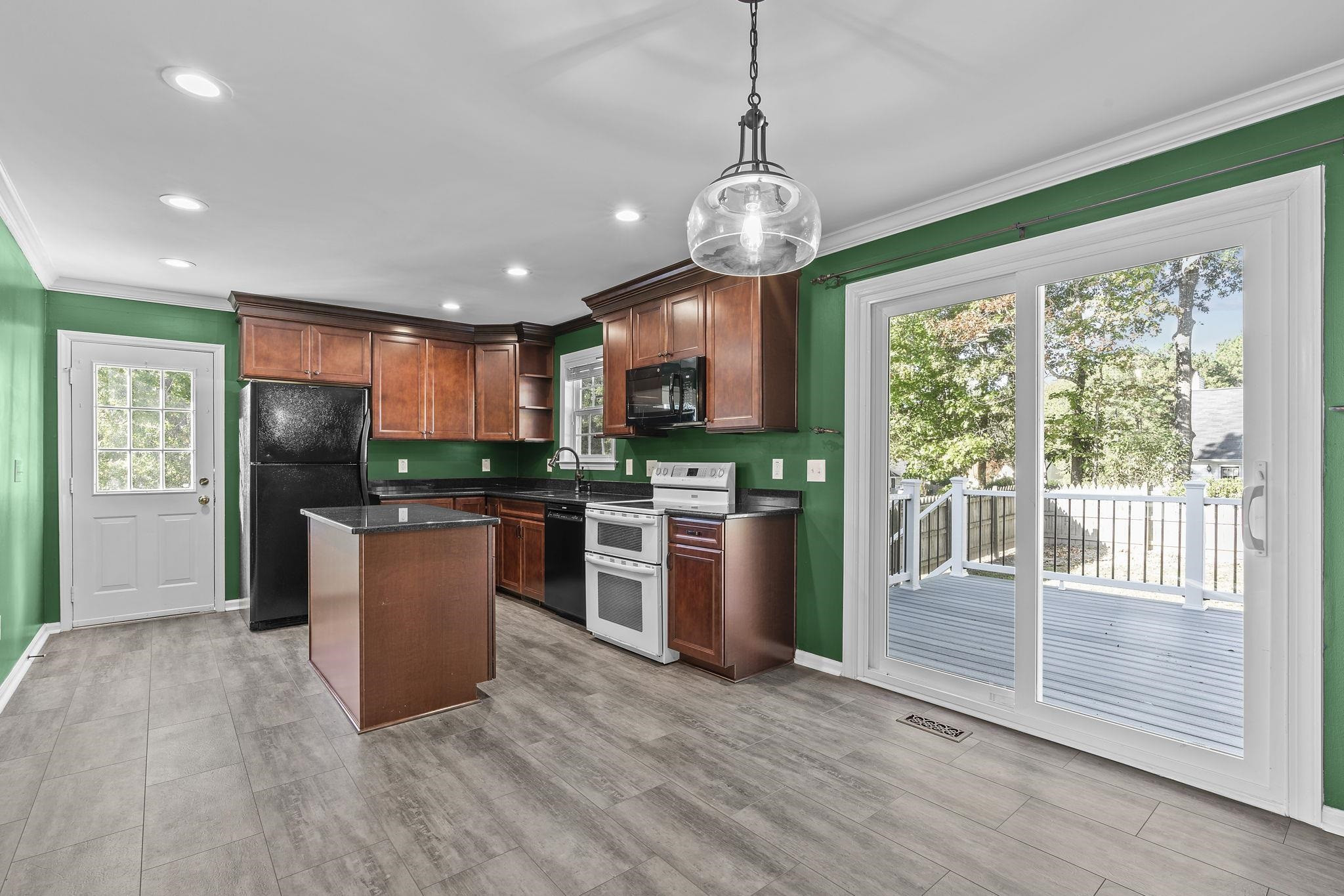 200 Peakhill Road Holly Springs, NC 27540 - Photo 6 of 18 a view of a kitchen with stainless steel appliances granite countertop a stove top oven a refrigerator with a dining table and chairs
