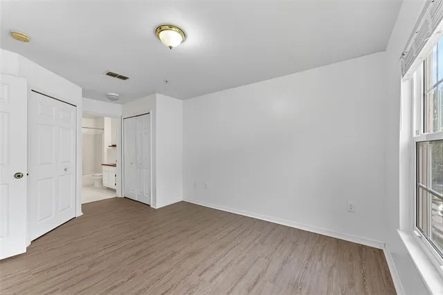 a view of a room with wooden floor and window