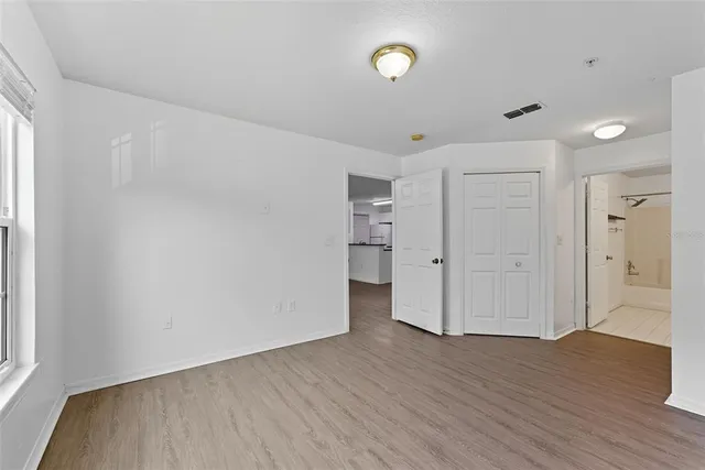 a view of empty room with wooden floor and window