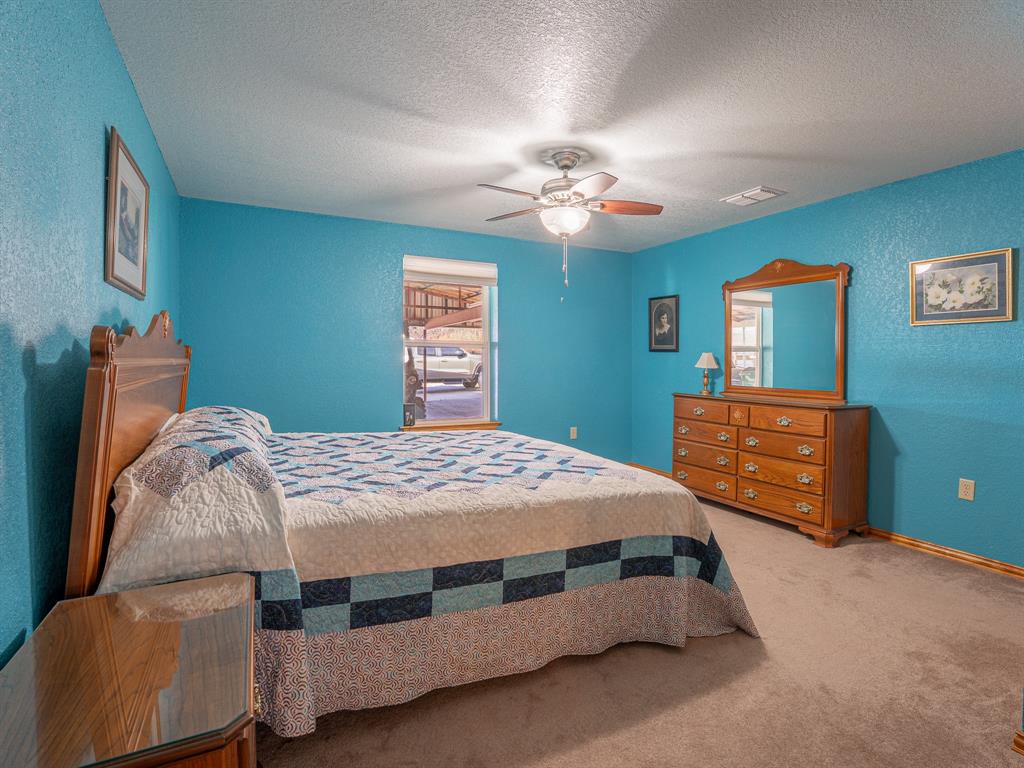 1857 Old Bonita Road Nocona, TX 76255 - Photo 14 of 39 a bedroom with a bed and a chandelier