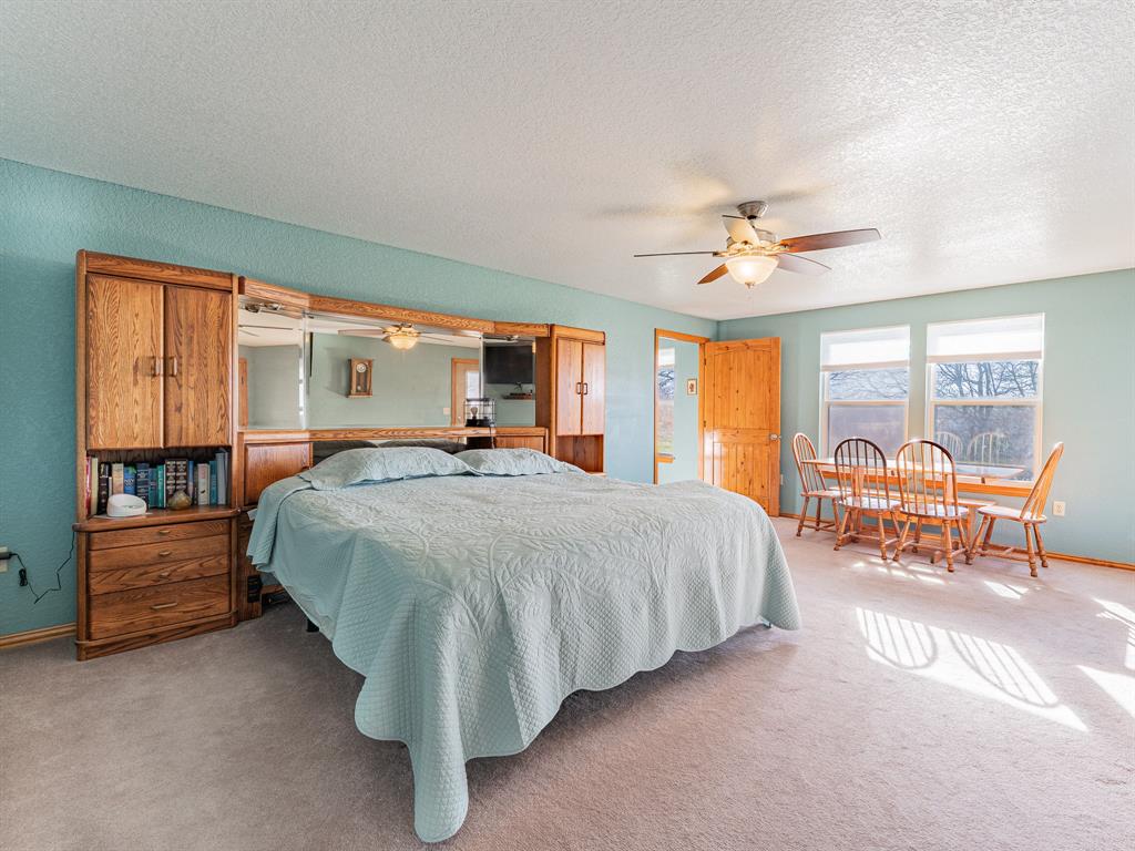 1857 Old Bonita Road Nocona, TX 76255 - Photo 10 of 39 a bed room with a bed and a chandelier