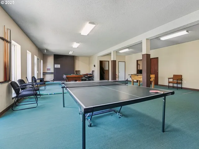 a living room with furniture pool table and a large window