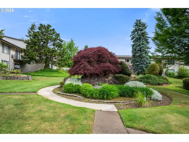 a view of house with a yard and potted plants