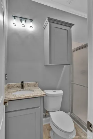 a bathroom with a granite countertop toilet sink and mirror