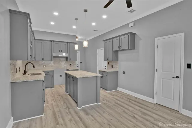 a kitchen with kitchen island a sink stainless steel appliances and cabinets