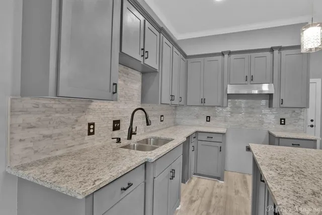 a kitchen with stainless steel appliances granite countertop a sink stove and cabinets