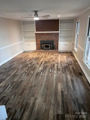 a view of empty room with wooden floor and fireplace
