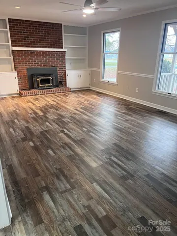 an empty room with windows and fireplace