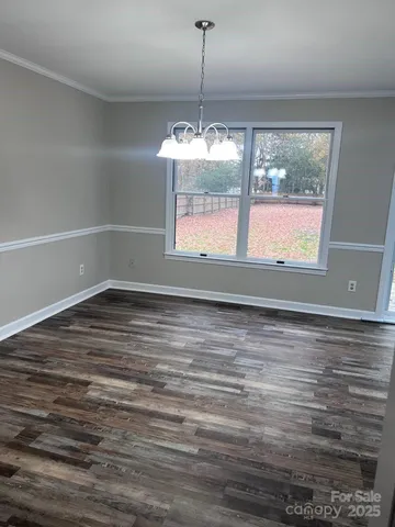 a view of a room with window wooden floor and front door