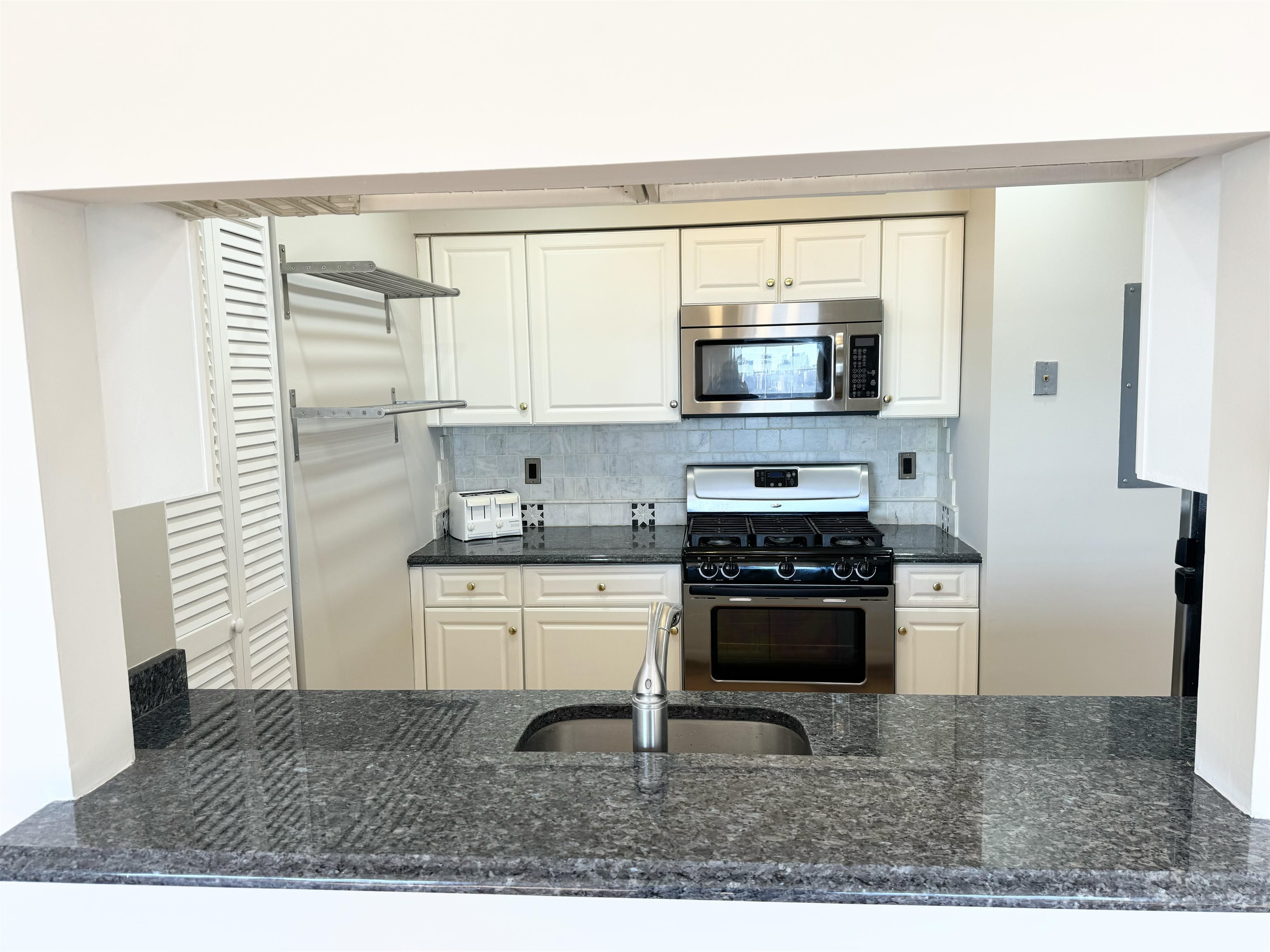 22 Bergen Ridge Road, Unit 2 North Bergen, NJ 07047 - Photo 3 of 15 a kitchen with stainless steel appliances granite countertop a stove a sink and a microwave