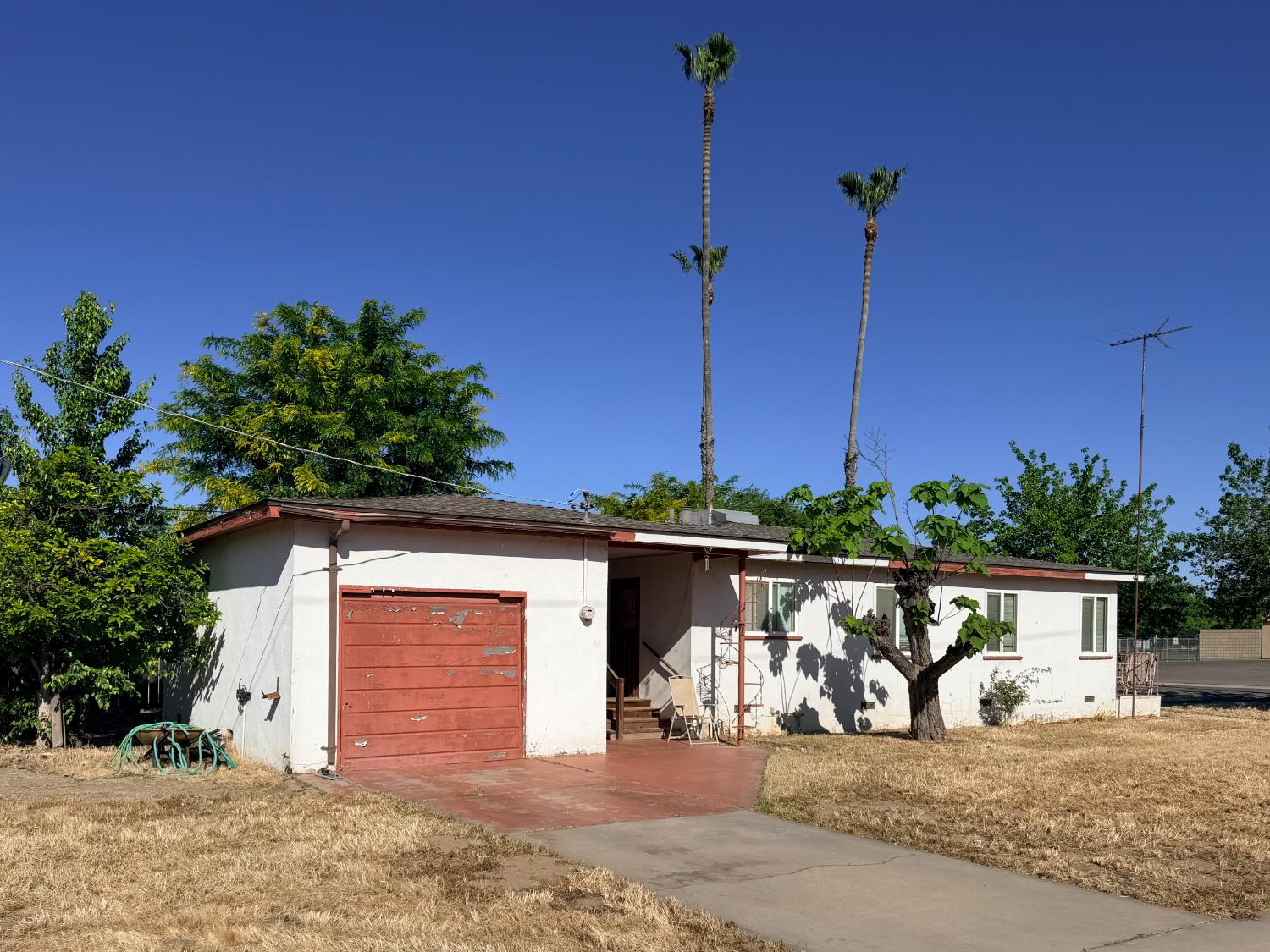 15445 West E Street Kerman, CA 93630 - Photo 2 of 12 a front view of a house with a yard and garage