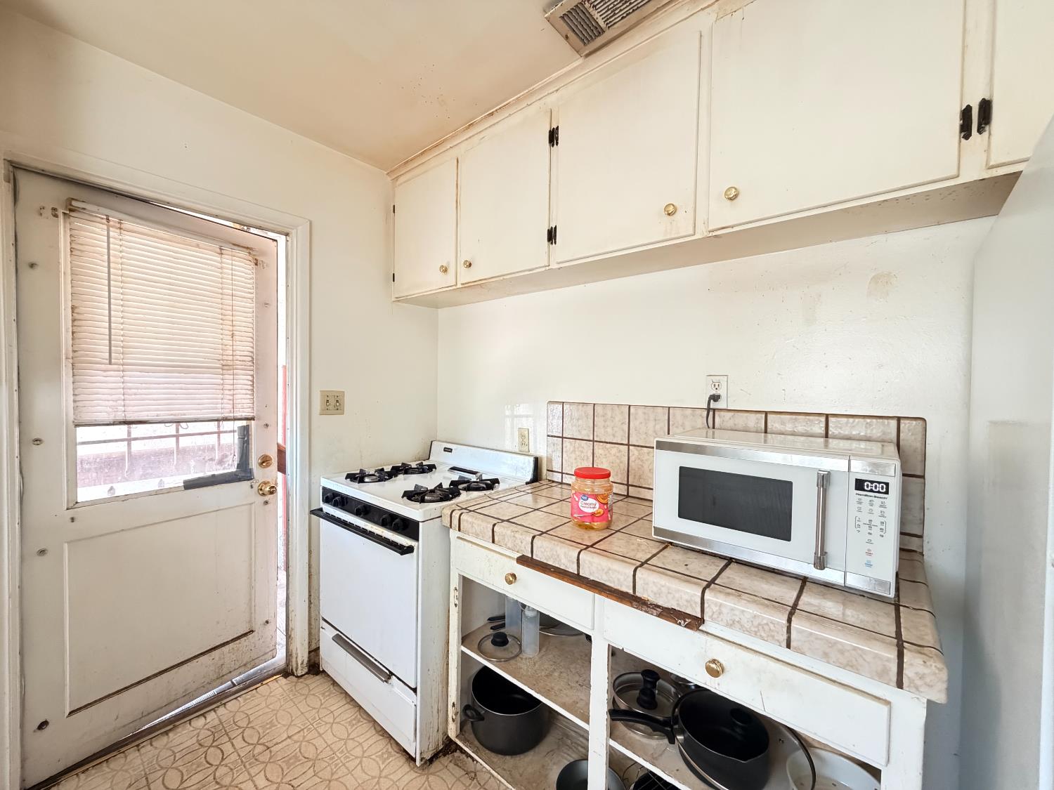 15445 West E Street Kerman, CA 93630 - Photo 6 of 12 a kitchen with a stove and a microwave