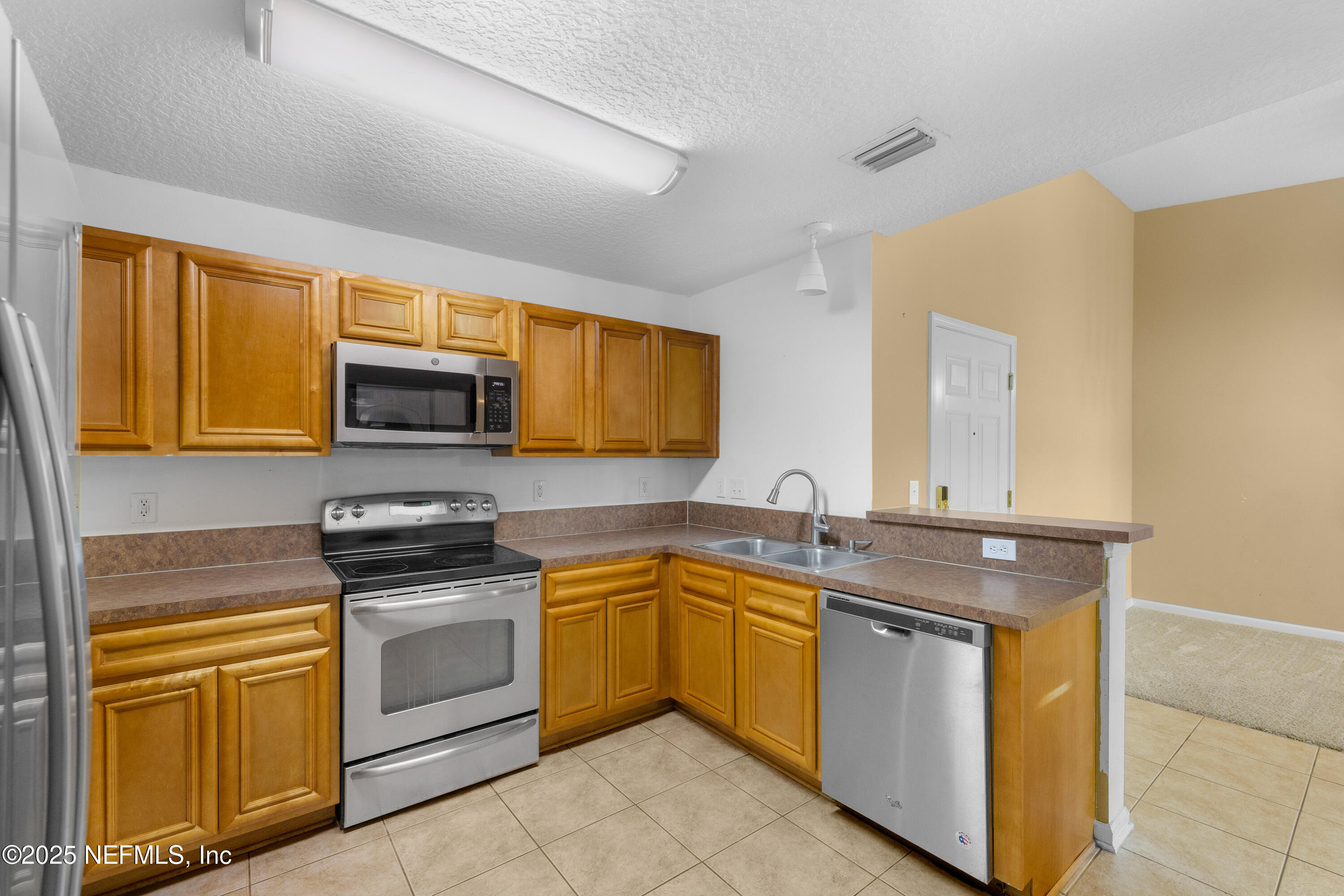 2784 Golden Lake Loop St. Augustine, FL 32084 - Photo 4 of 32 a kitchen with stainless steel appliances granite countertop a sink stove and microwave