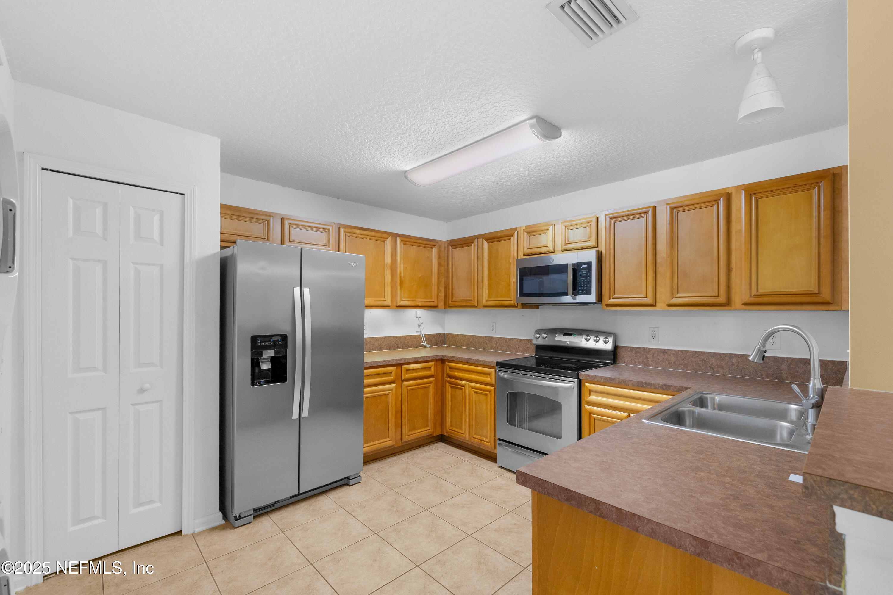 2784 Golden Lake Loop St. Augustine, FL 32084 - Photo 5 of 32 a kitchen with stainless steel appliances granite countertop a refrigerator a stove top oven a sink and dishwasher