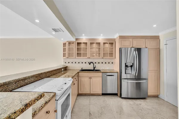 a kitchen with white cabinets and appliances