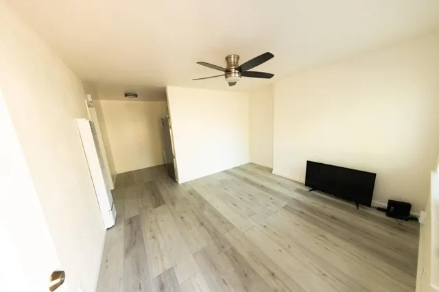 a view of empty room with wooden floor