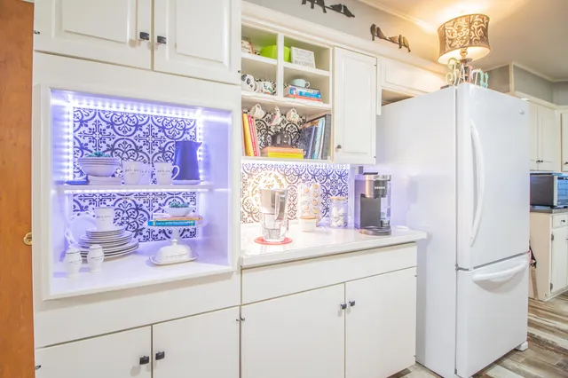 a kitchen with granite countertop white cabinets and white appliances
